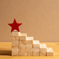 Photo shows the building blocks that look like stairs that reach toward a star at the top, representing how the steps to build a great compensation philosophy are chosen carefully and thoughtfully.